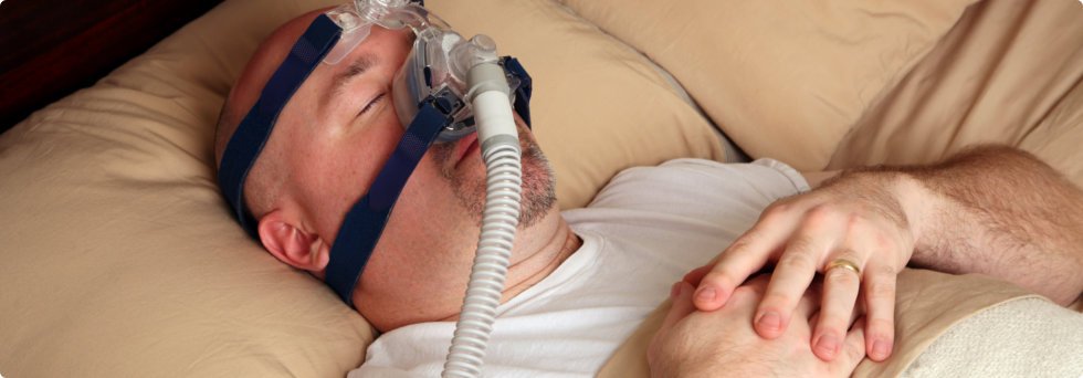 Man lying on bed with oxygen mask